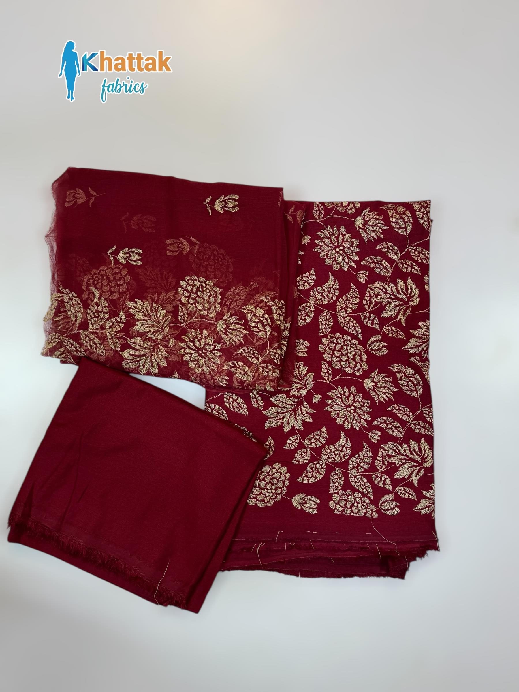 An unstitched 3-piece Winter Karandi suit in maroon, showing the embroidered shirt, chiffon dupatta, and plain trouser in a flat lay style.